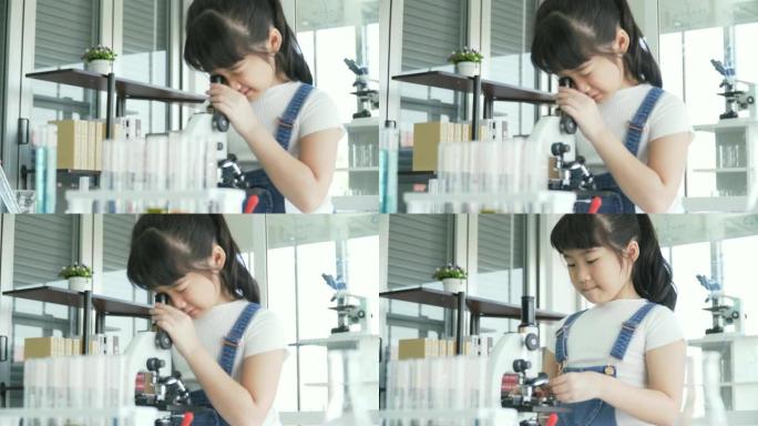 dolly拍摄的侧视图: 好奇的亚洲女孩根据自己的意愿调整光学显微镜