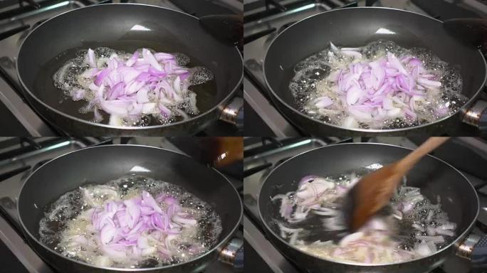 特写女人在家里的厨房的燃气灶上，用锅里的油在锅里煎炸洋葱片。烹饪食物。