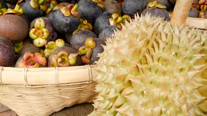 混合季节热带甜多汁水果，泰国当地市场。大月榴莲，坚硬的皮肤覆盖着尖锐的点和山竹，国王和王后，最美味的