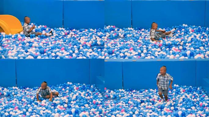 可爱的亚洲儿童男孩玩得很开心在操场上玩滑块，在游泳池里玩彩色塑料球，在泰国的球房或禁球。视频4k慢动