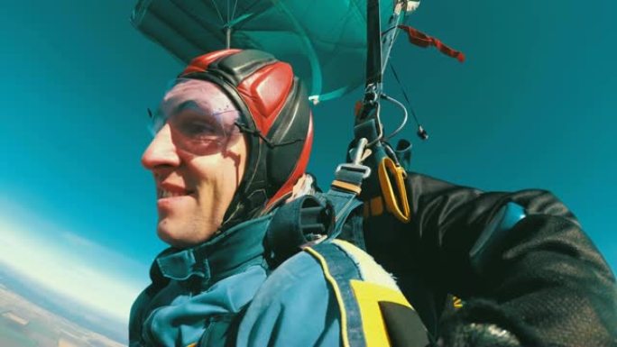 跳伞运动员在敞开的降落伞下一前一后飞行。慢动作