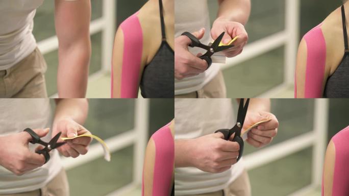 男性双手拿着一卷黄色胶带，测量它，用剪刀剪两片，修剪它们。制备稳定肩关节的kinesiotape