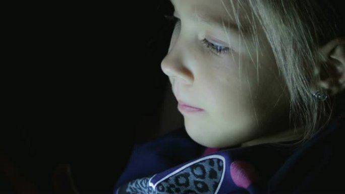女生晚上在黑暗中玩平板电脑