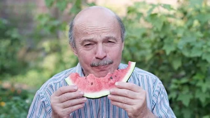 老人在炎热的夏天吃西瓜。