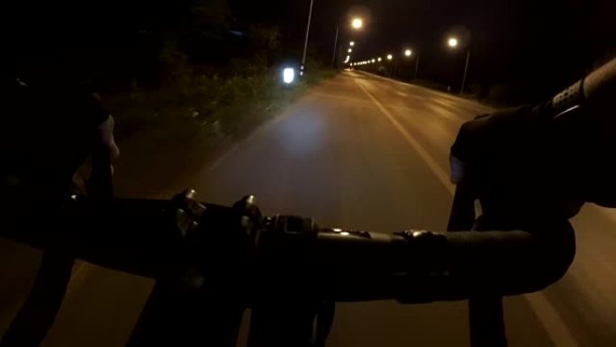 POV骑自行车，晚上带公路赛车的通勤者