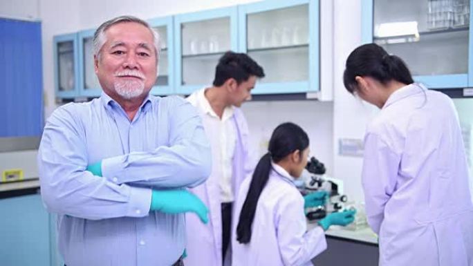 在实验室肖像中工作的科学家。资深中国男科学家与他的团队一起从事实验室肖像工作。