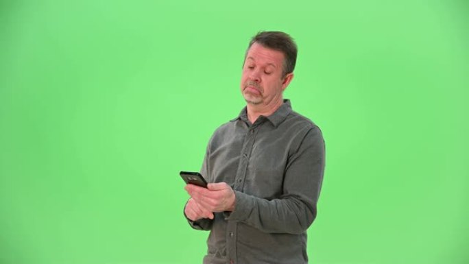 成年白人男性与手机互动，就像他使用约会服务一样，在绿色屏幕上左右滑动