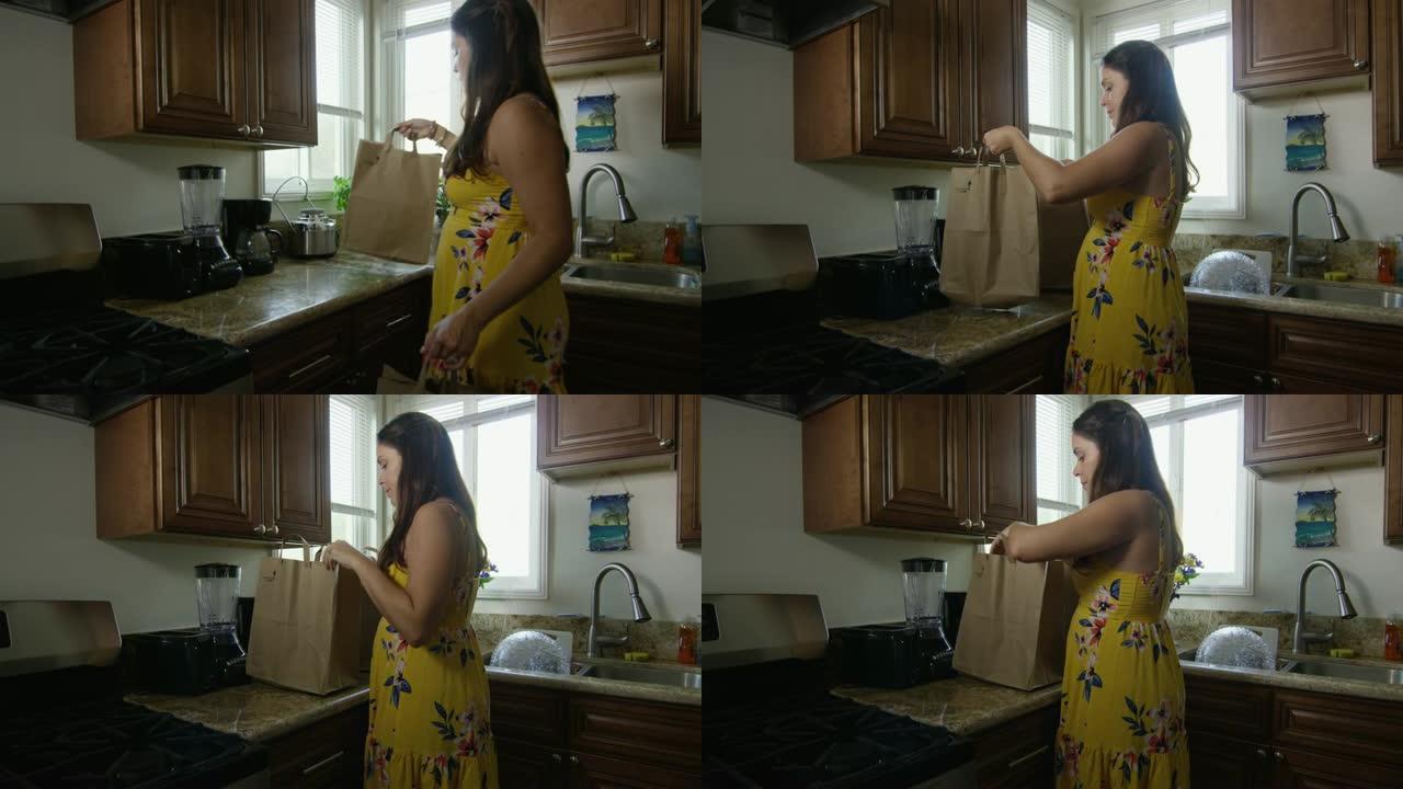 孕妇带着购物袋进入厨房的慢动作