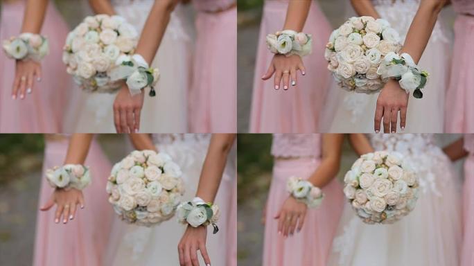 穿着粉红色礼服的新娘和伴娘捧着花束。