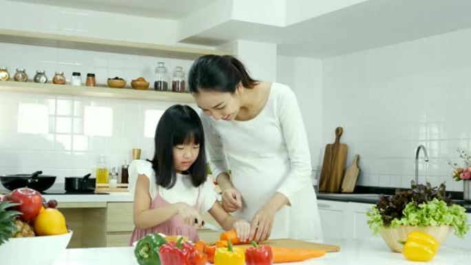 小女孩试着在厨房自己做饭。母亲教女儿做饭。有生活方式和健康观念的人。