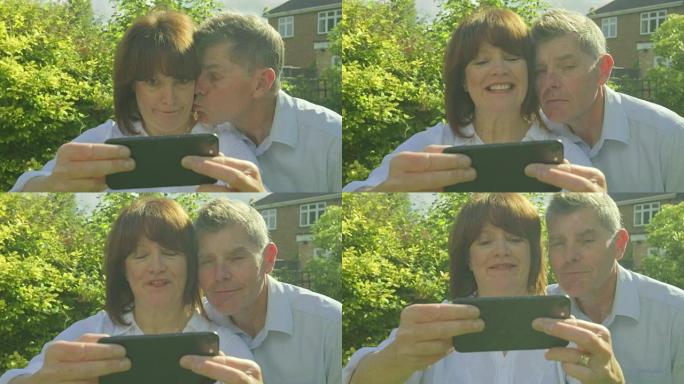 高级夫妇在智能手机上自拍并做鬼脸