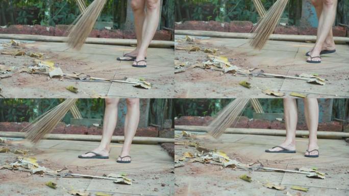一个女人的特写镜头在户外扫干树叶