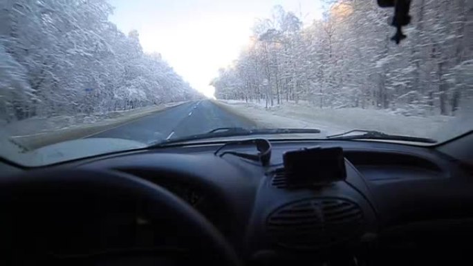 男子在冬季道路上缓慢驾驶汽车。在冬天，大多数驾车者仍然放慢脚步，要小心。