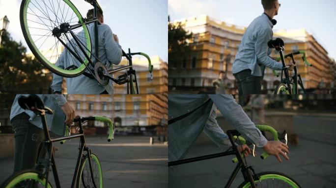 穿着休闲服和太阳镜的英俊年轻白人男子在城市上楼时，肩上扛着一辆自行车。罕见的低角度镜头