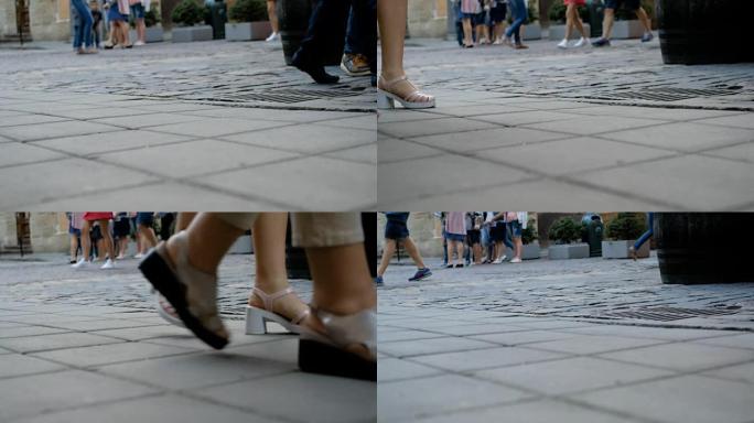 穿鞋的人的脚走在石头路上。在城市里散步。