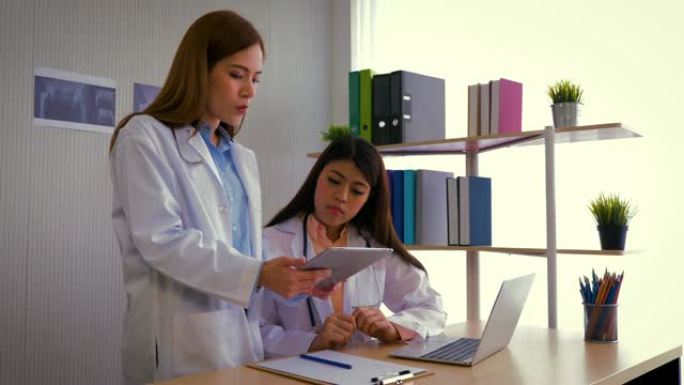 两名年轻的亚洲女医生与放射科医生讨论诊断，在临床，医疗保健和医疗概念中检查x射线