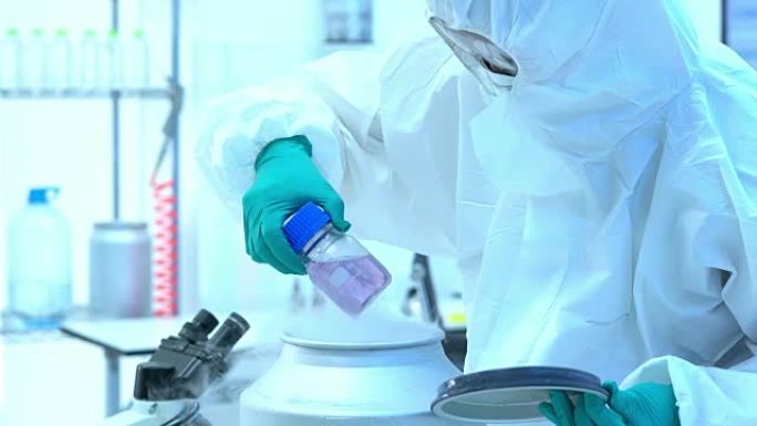 科学家穿着防护服，正在将化学药品从存储安全中取出。科学、测试开发和实验室行业的概念。