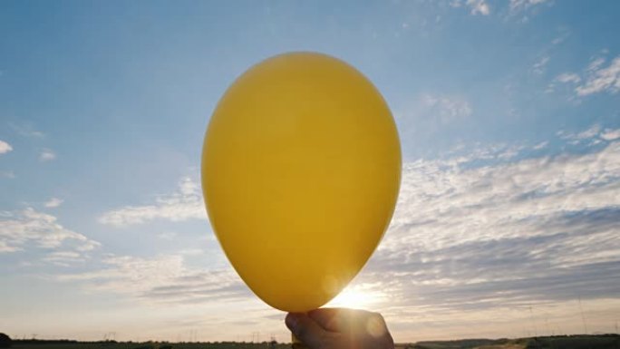 空气来自黄色的气球，它变得li行。在蓝天的背景下