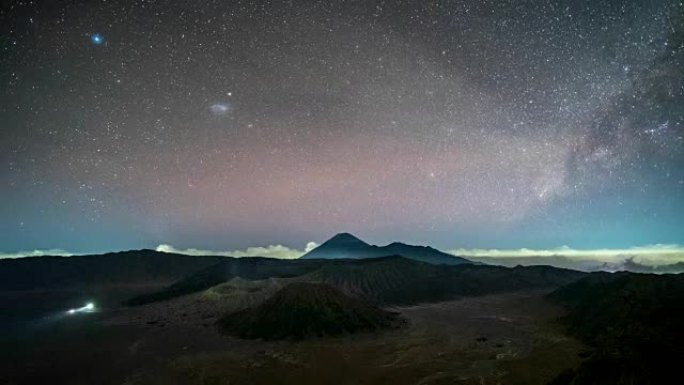 火山的延时在夜间活跃着银河和交通繁忙。印度尼西亚东爪哇省布罗莫腾格尔塞梅鲁国家公园