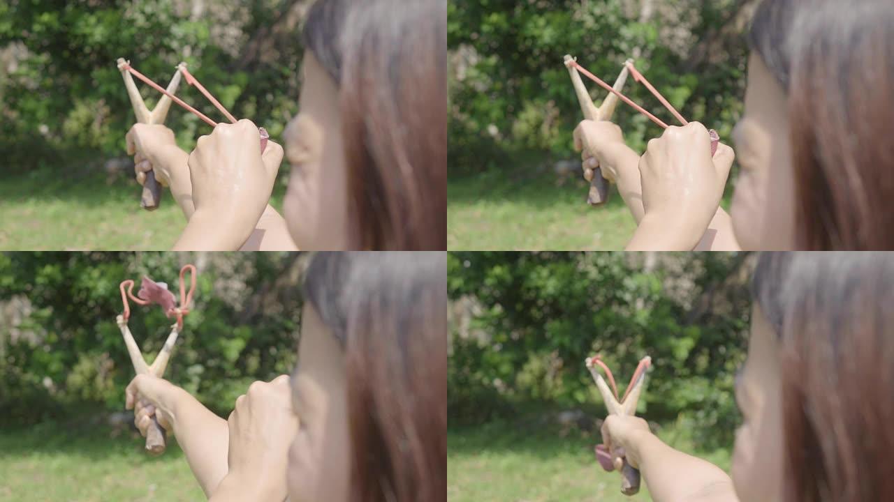年轻的亚洲女子瞄准弹弓
