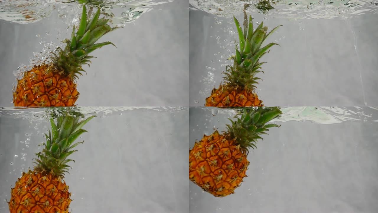 菠萝以慢动作浸入装有气泡的水容器中。菠萝被隔离在白色背景上。