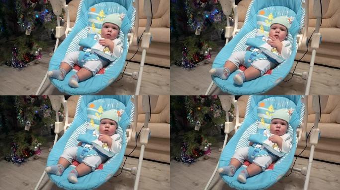 新生男孩在自动电动婴儿椅上摇摆