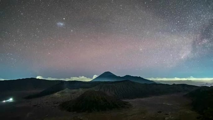 火山的延时在夜间活跃着银河和交通繁忙。印度尼西亚东爪哇省布罗莫腾格尔塞梅鲁国家公园