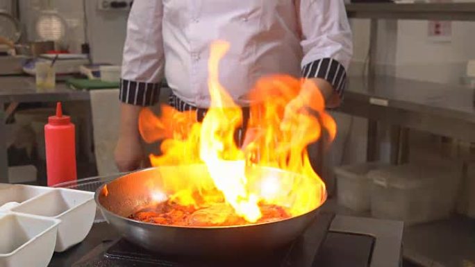 着火做饭。厨师用火在锅里煮蔬菜和肉。餐厅。意大利菜。健康饮食。1080p
