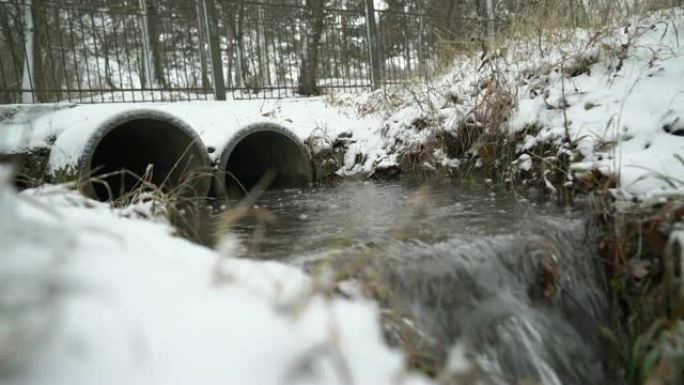 冬季两根混凝土排水管流出的水