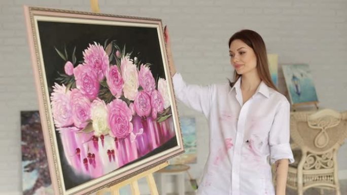 一幅画着牡丹花的画附近的艺术家女孩的肖像。