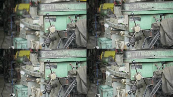 钻机存放在旧肮脏的车库里。慢移焦点手持慢动作镜头，29.97fps。