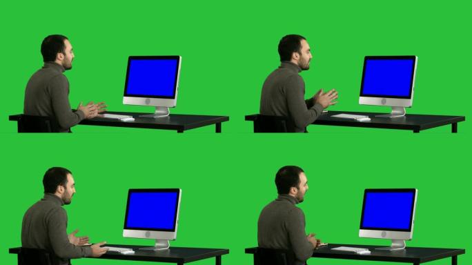 年轻的商人在绿色屏幕上的计算机上进行视频通话，色键。蓝屏模拟显示