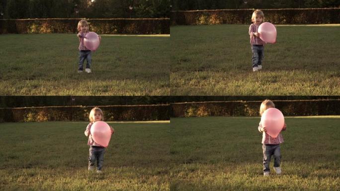 小女孩在日落时在公园里带着紫色的球奔跑