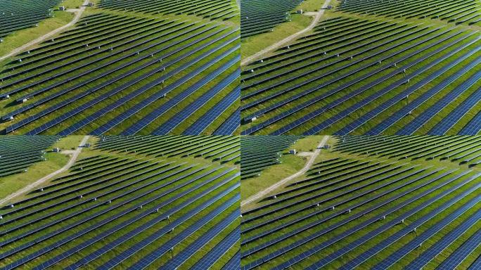 法国南部两个蓝色太阳能电池板的鸟瞰图。数百块太阳能电池板在绿草地上，在蓝天下的阳光照射下。两条田野之