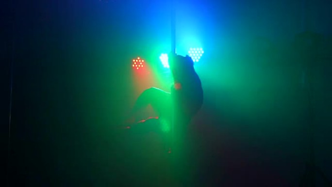 一个女孩在钢管上跳舞的剪影。钢管舞
