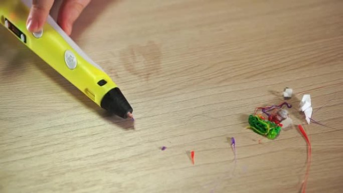 桌子上是一支3D笔。ABS塑料的垃圾和残留物附近