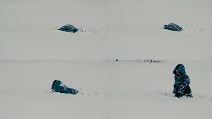 男孩在冬天在雪堆里玩耍。