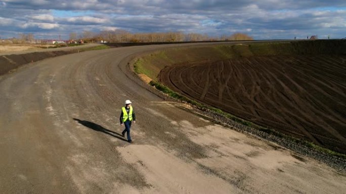 头戴白色头盔，去检查道路的建设。航空勘测。