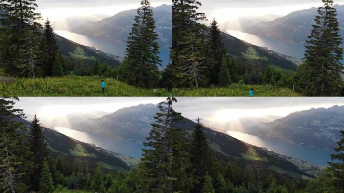 日落时在瑞士阿尔卑斯山拍摄湖泊的妇女的风景鸟瞰图