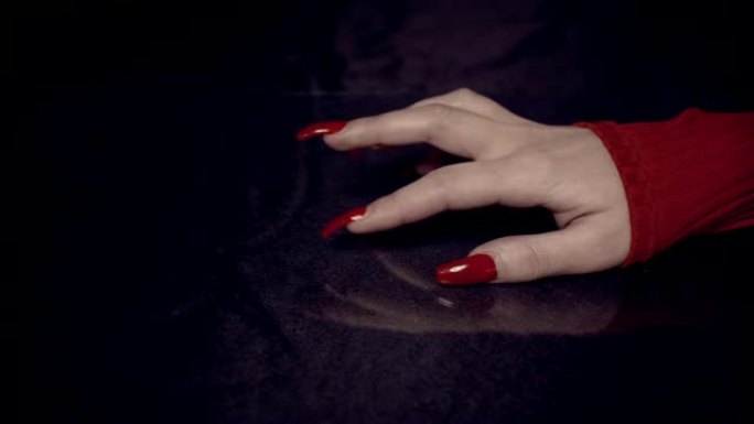 长着红色指甲的女性手。