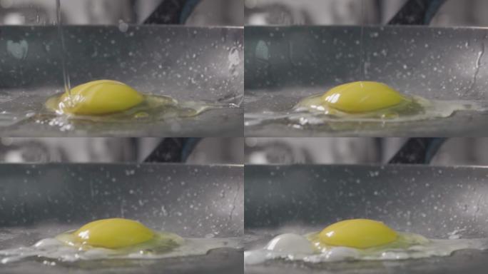 鸡蛋掉进煎锅里。慢动作