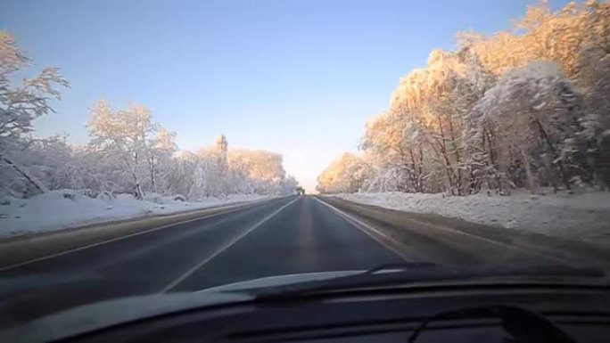 男子在冬季道路上缓慢驾驶汽车。在冬天，大多数驾车者仍然放慢脚步，要小心。