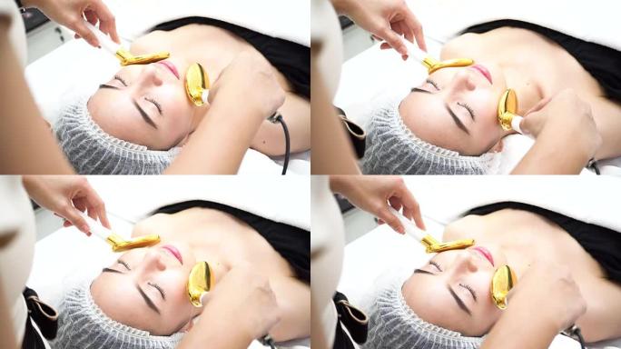 亚洲妇女在美容诊所脸上得到金勺医疗美容设备。改善皮肤光滑度并治愈痤疮的药物治疗