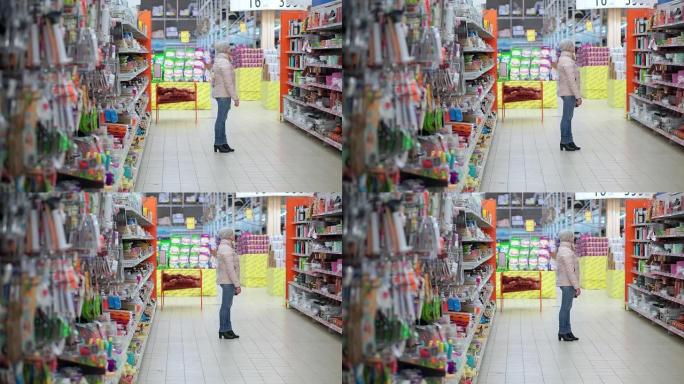 一个戴着帽子和羽绒服的女人穿过超市。她看着货架上的商品，选择购买。
