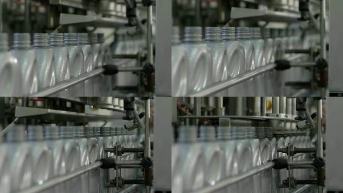 机油灌装机，工厂移动输送线上的一排灰色塑料瓶