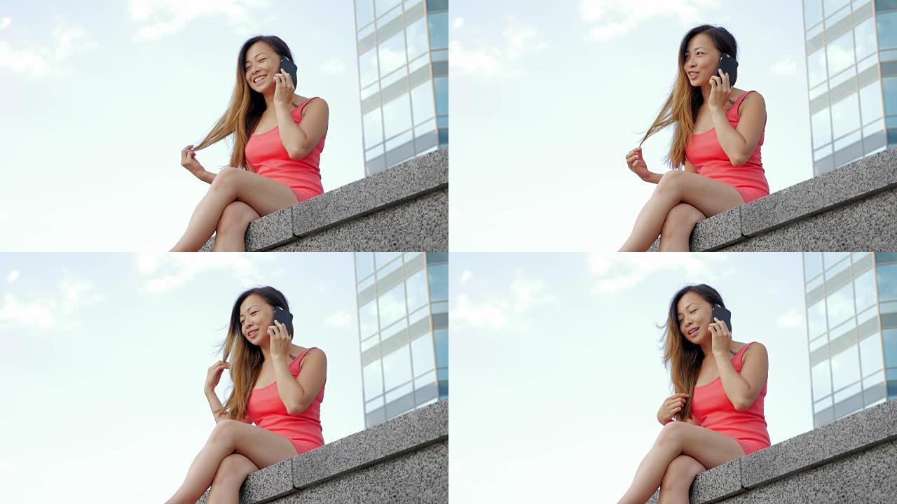 美丽的亚洲女人在城市里用智能手机聊天