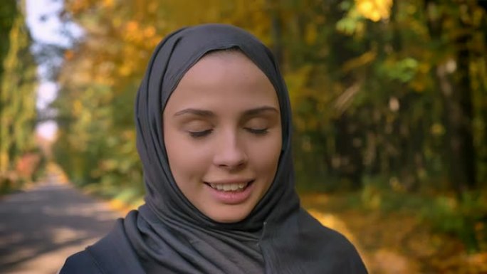 戴着头巾的年轻穆斯林女孩的特写肖像对着镜头，试图喘口气。