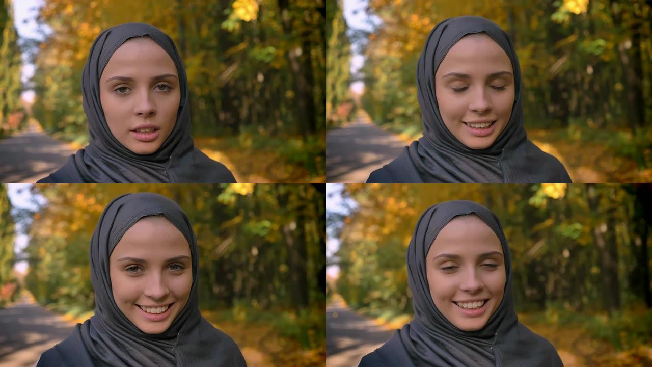 戴着头巾的年轻穆斯林女孩的特写肖像对着镜头，试图喘口气。
