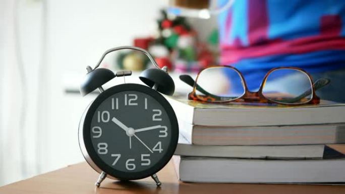 桌子上的闹钟，眼镜，书籍和一杯咖啡