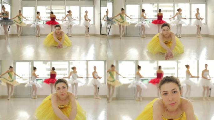 穿着黄色连衣裙的芭蕾舞演员坐在地板上